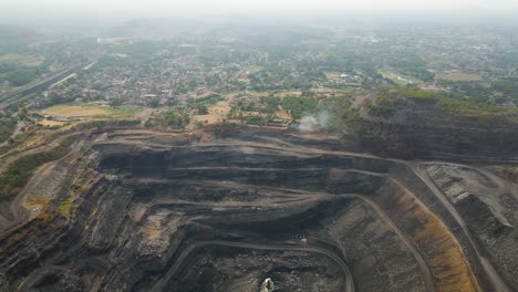 vista aérea panorámica de las minas de carbón en dhanbad, con grandes pozos abiertos y maquinaria activa.