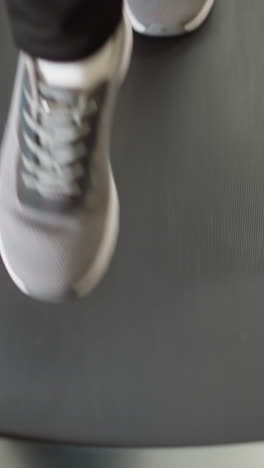 woman uses in-home treadmill closeup. fit lady in sports footwear engages in jogging session on house-based exercise device slow motion. fitness routine