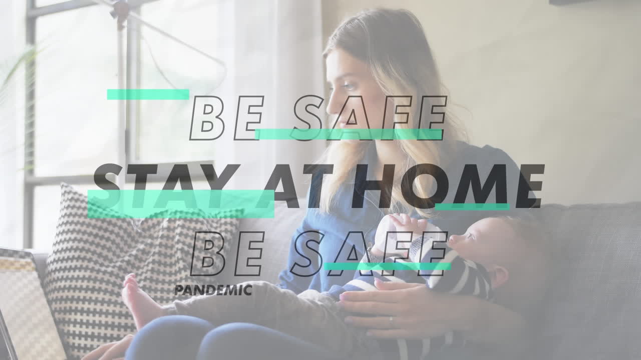 赤ちゃんに ⁇ をあげている白人の女性の上に閃く社会距離のメッセージのアニメーション