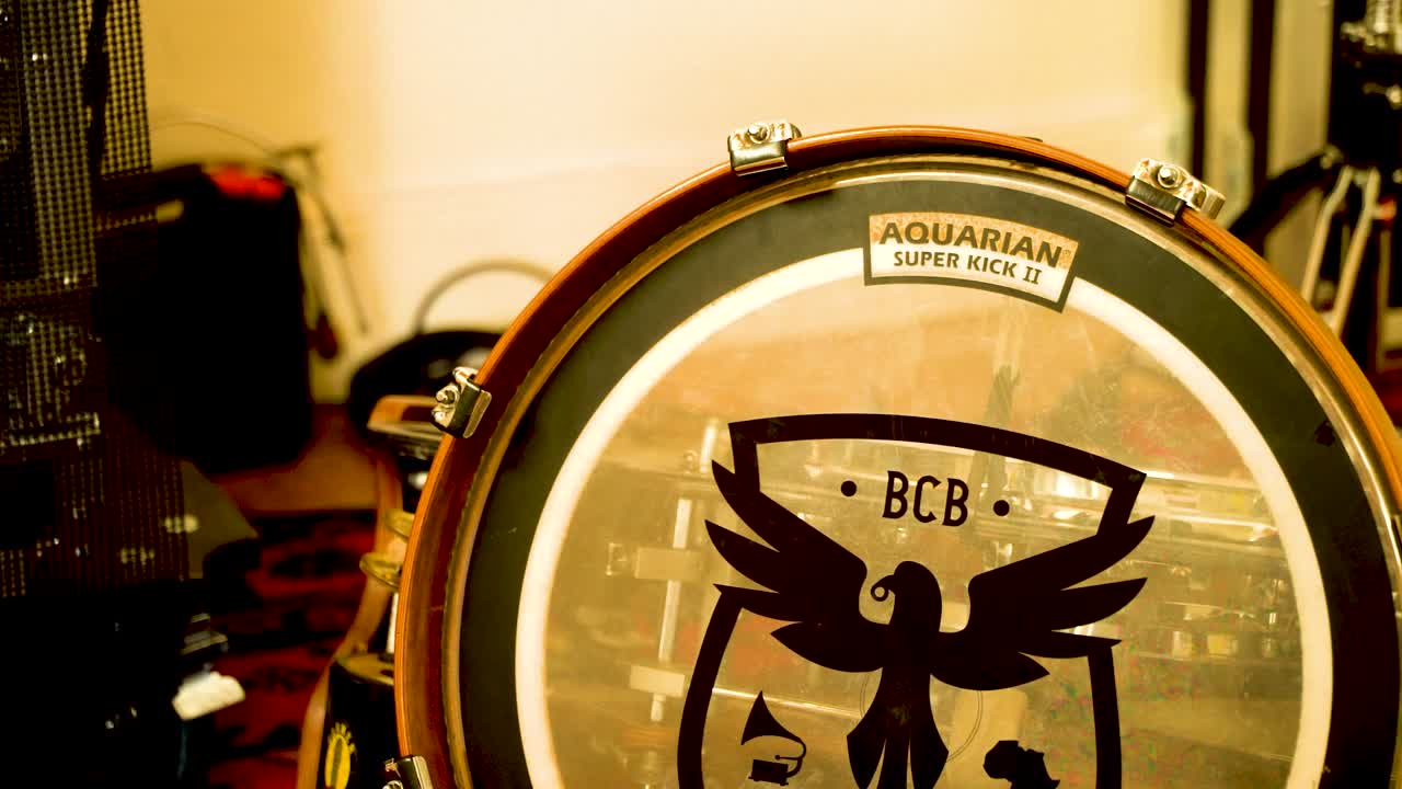 음악실 의 환영적 인 분위기 가운데, 반 ⁇ 이는 황금색 드럼 세트 가 무대 의 중심 을 차지 한다