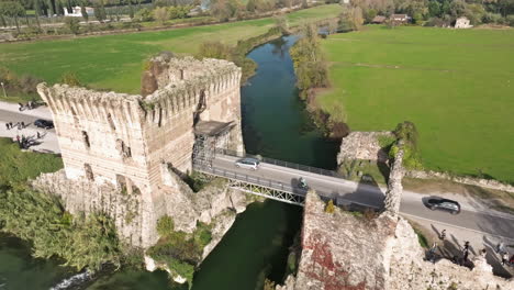 Vuela-Sobre-El-Puente-Medieval-Sobre-La-Naturaleza-Rural-Cerca-De-Borghetto-Sul-Mincio,-Norte-De-Italia