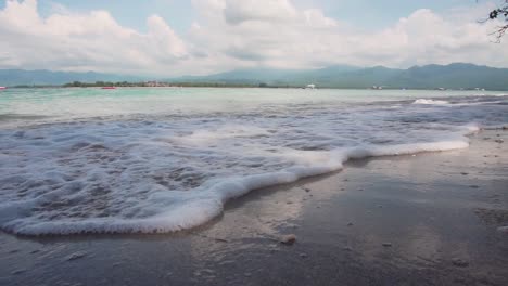 Low-angle-small-wave-rolling-onto-island-beach