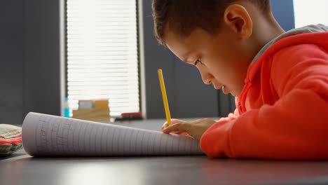 Side-view-of-attentive-Asian-schoolboy-studying-at-desk-in-classroom-at-school-4k