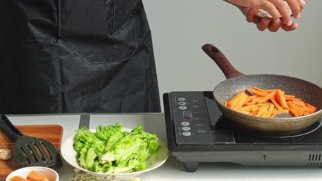 cooking carrots and lettuce on an induction stove