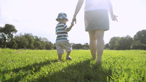 mother and baby boy holding hands walking