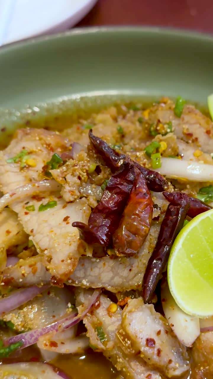 신선한 맥주와 함께 매운 태국 돼지고기를 즐기고 있습니다.