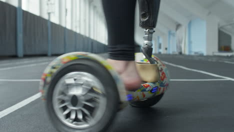 man with prosthetic foot spinning on hoverboard in stadium