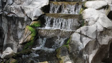 water flowing down a mossy, rocky waterfall