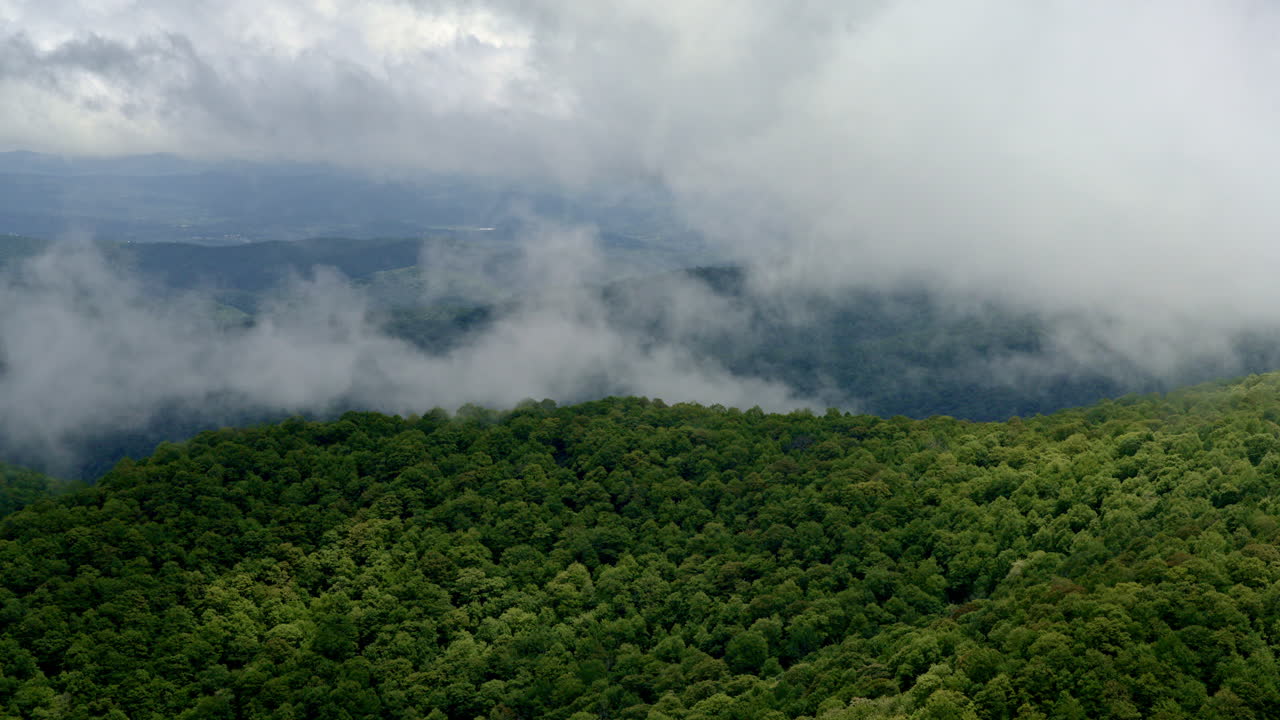 Cinematic drone view as fog and clouds engulf the Smoky Mountain ridges