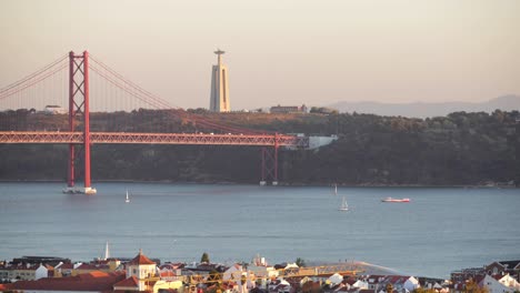 fantastic moment to see cristo rei in a sunset from lisbon while the boats crossing the river