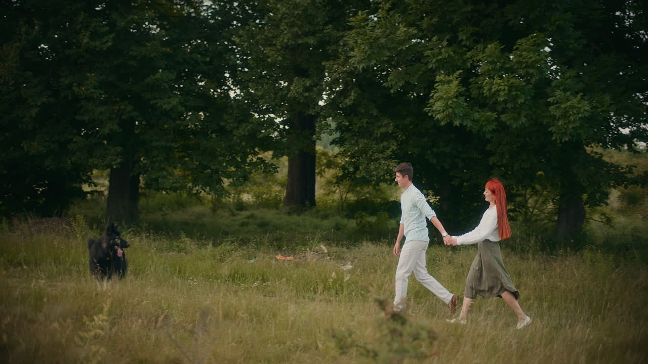 Couple walking with dog in a field