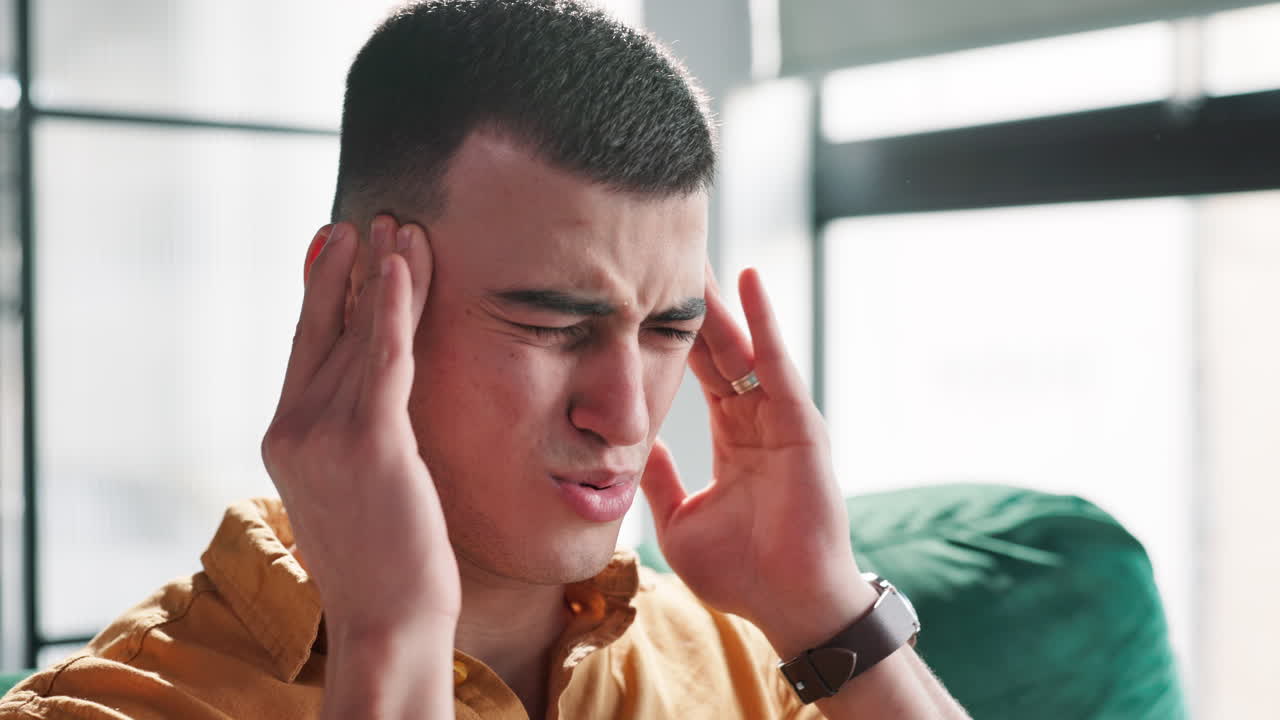 남자가 두통을 겪고 있습니다.