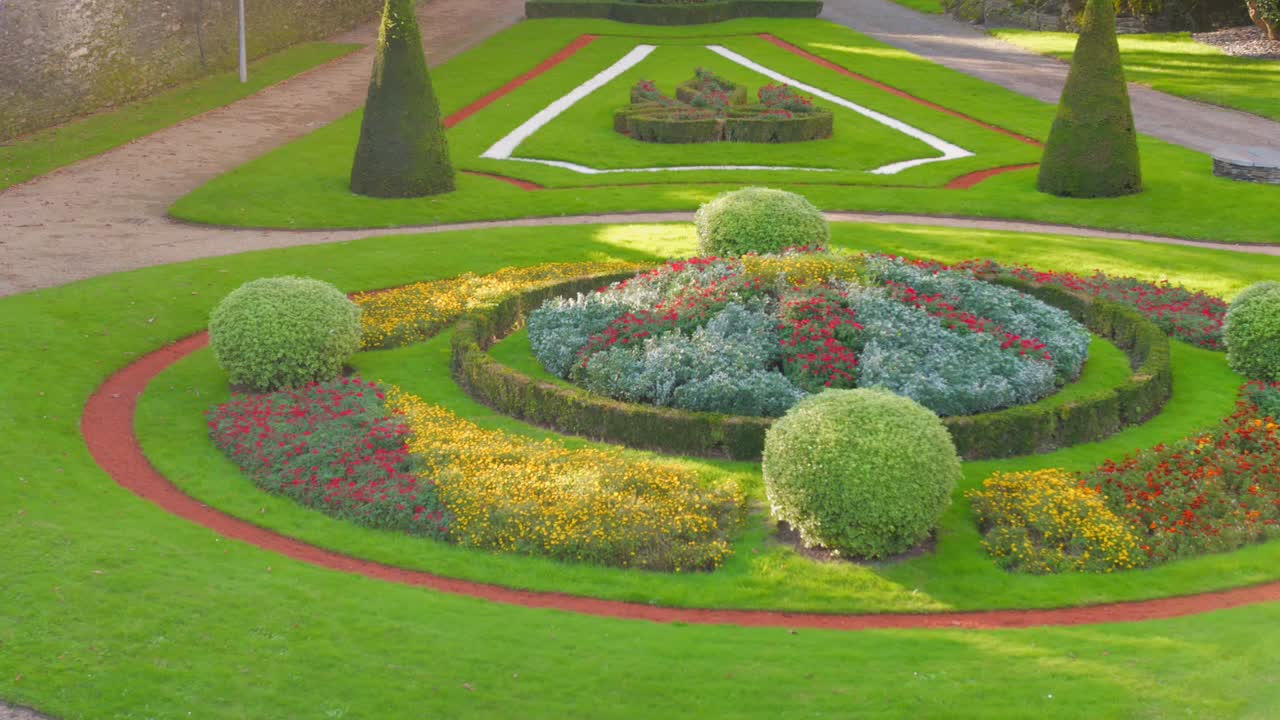 Formal castle garden with colorful flower beds in Angers, France, sunny and calm