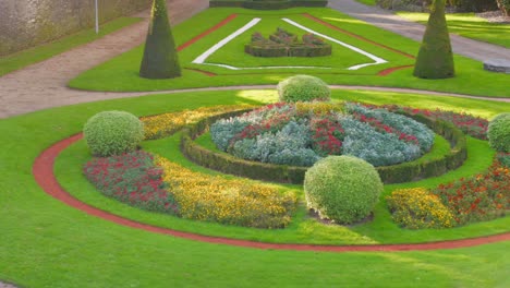 formal castle garden with colorful flower beds in angers, france, sunny and calm