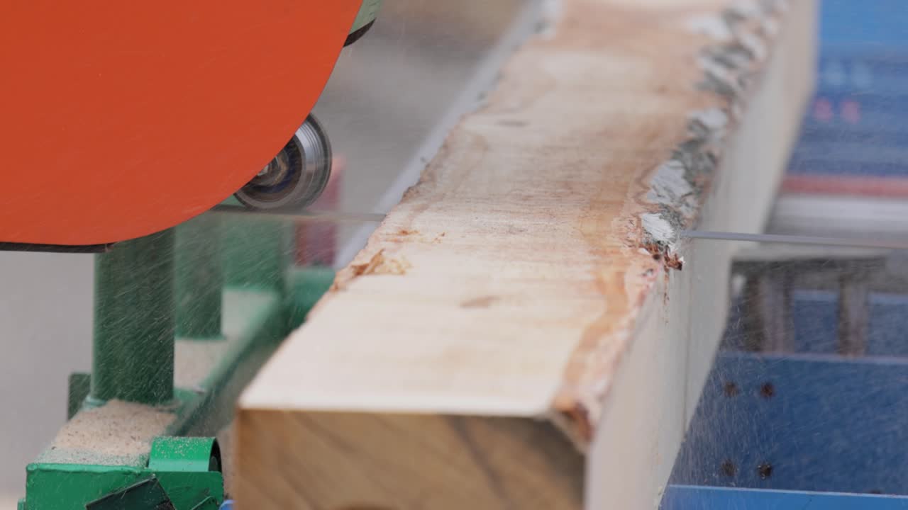 работа лесопилки в крупном плане. процесс обработки бревен в оборудовании лесопильная машина пила ствол дерева на досках.