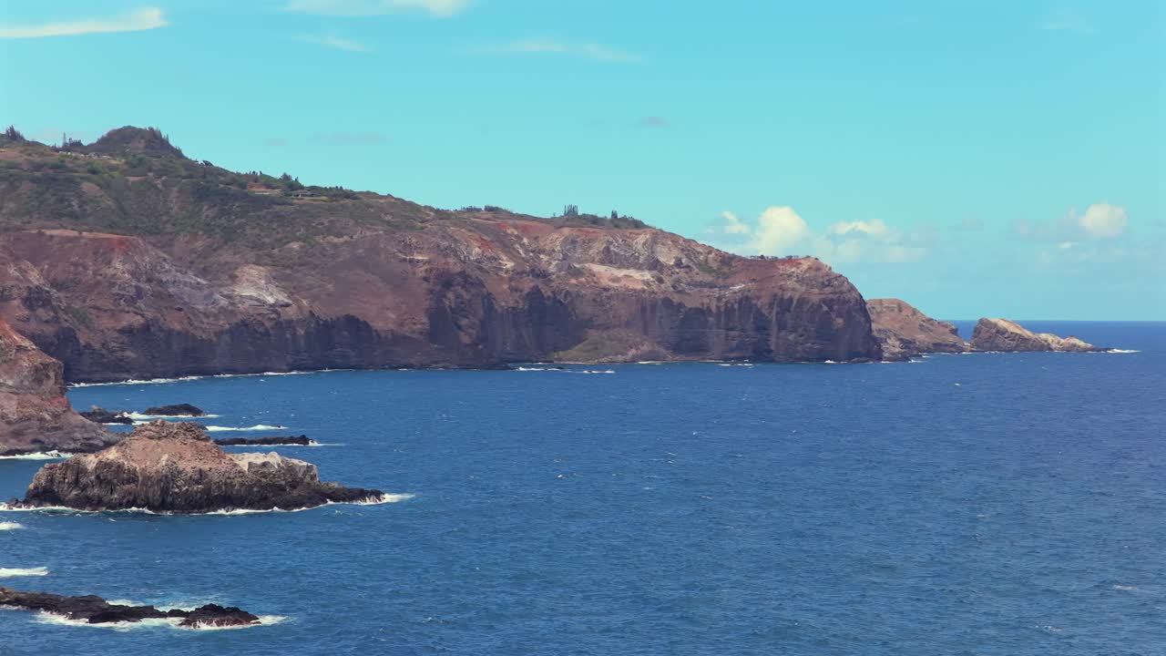 Drone pans across a rocky Hawaiian shore rarely seen by visitors, revealing epic cliff faces in close up with dramatic panning camera movements. Perfect for adventure tourism and establishing shots