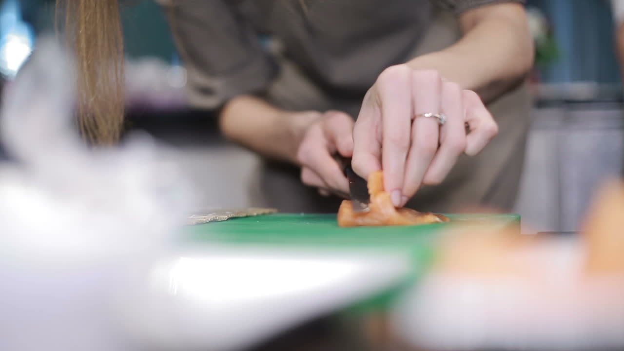 Preparing Sushi On Workshop. Female cooks preparing sushi in the restaurant kitchen