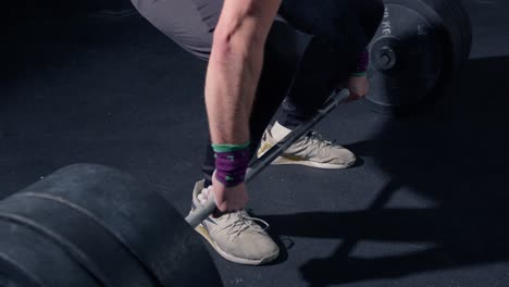 close up of man doing deadlift after putting magnesium on hands