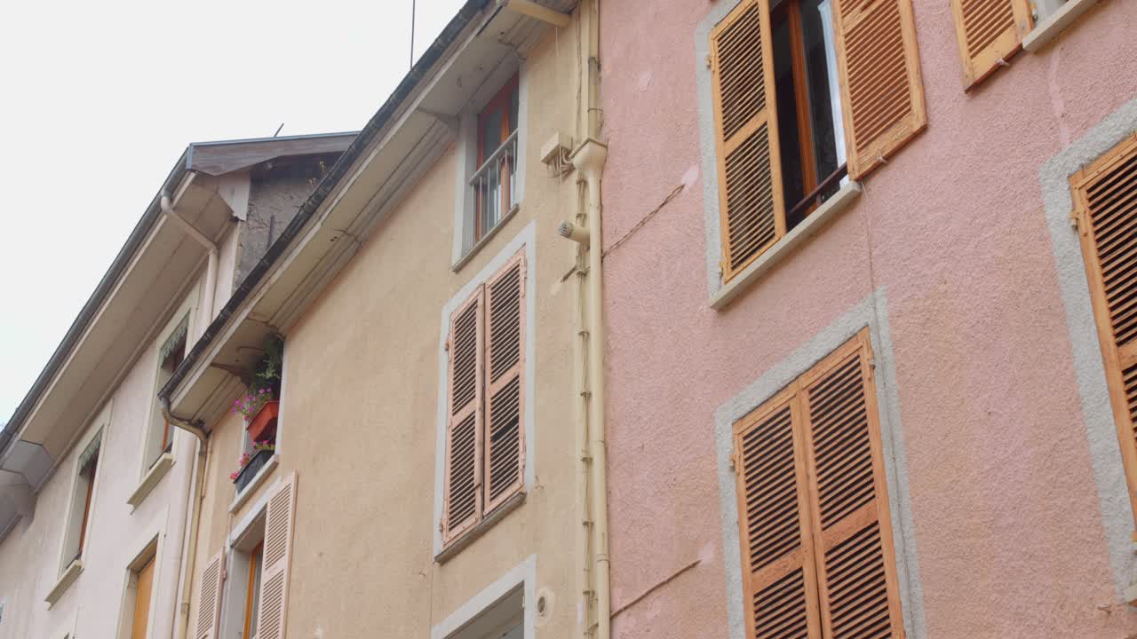 Colorful facades of old town buildings with wooden shutters in Vizille, France, daytime view