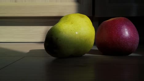 Ein-Apfel-Und-Eine-Birne-Im-Sonnenuntergang,-Mit-Dolly-Bewegung