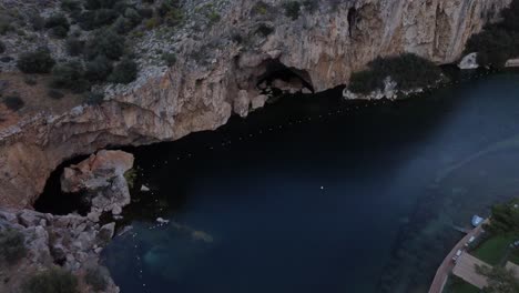 vista aérea del lago sumergido vouliagmeni en atenas, grecia y los acantilados circundantes | 4k