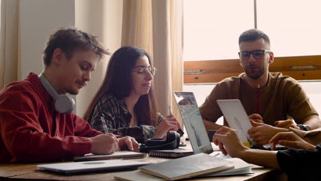 grupo de estudio hablando entre ellos sentados en una mesa en casa