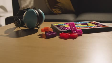 ear defenders and interlocking shape puzzle on table at home for child diagnosed with asd 2