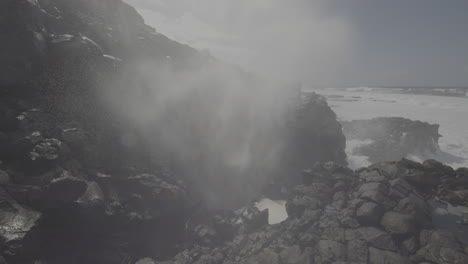 powerful ocean waves crashing against volcanic rocks, creating a blowhole