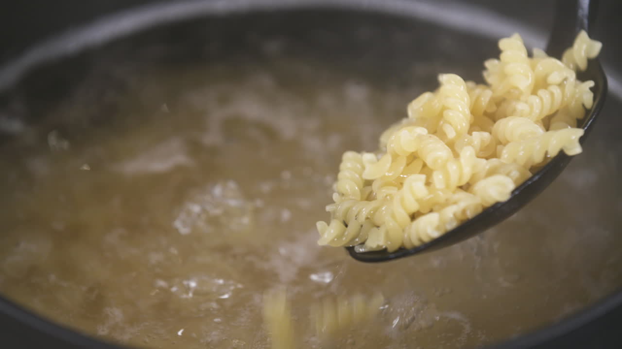 cocinar fideos de pasta fusilli en una olla, comprobar la cocción de los fideos de pasta, pasta al dente