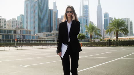 elegant businesswoman with phone outdoors