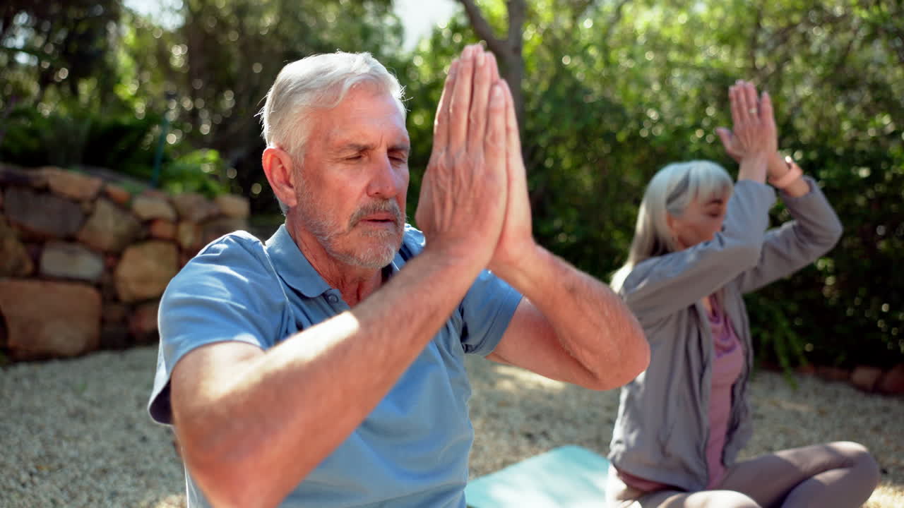 Seniorenpaar praktiziert Yoga und Meditation im Freien