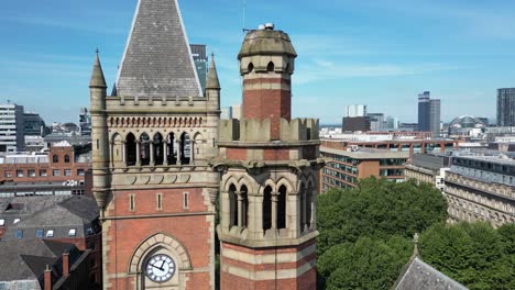 aerial drone flight around manchester crown court clocktower with a skyline view of manchester skyscrapers