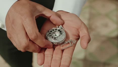 hands reveal intricate vintage pocket watch with gentle care