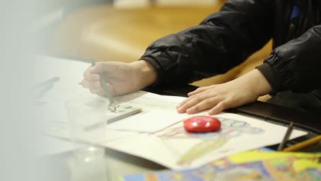kids drawing with colored pencils. kids sitting at table and drawing with colored pencils