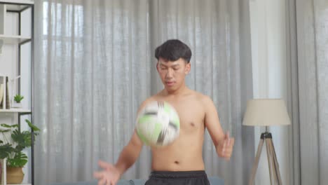 asian teenager boy doing football skills during the shirtless workout at home