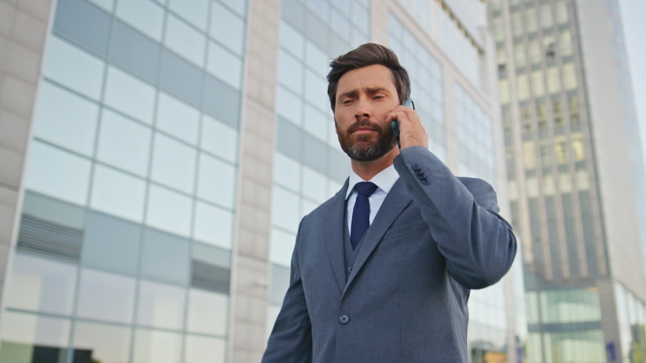 CEO discutindo trabalho em chamada de smartphone na rua, em close-up. Empresário encerrando a conversa.