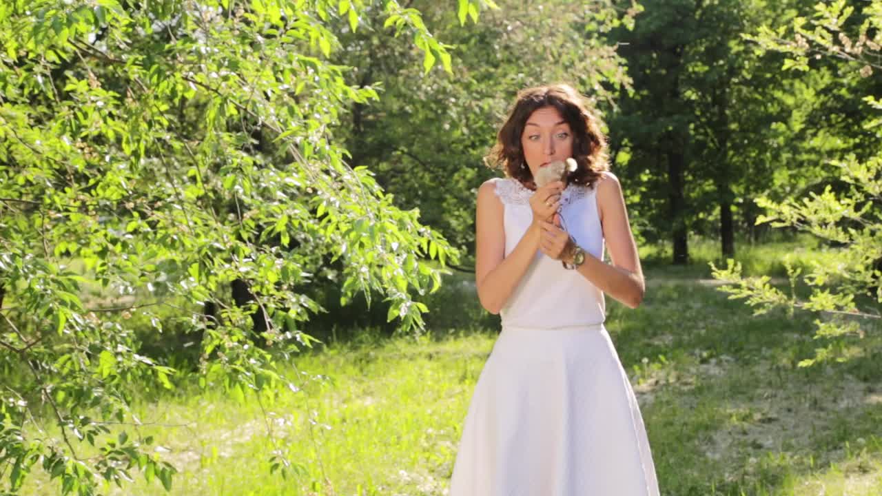 Woman Blowing a Dandelion in a Park