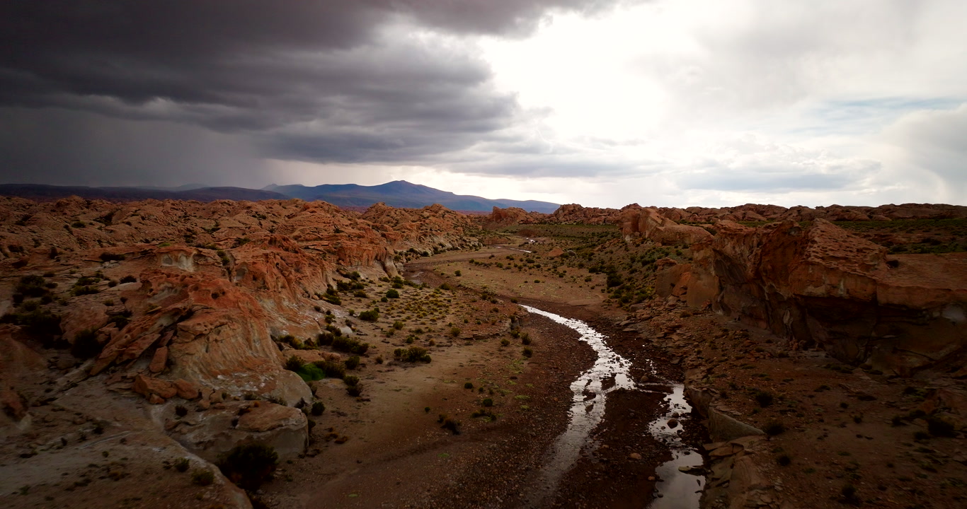 River snakes through valley of Siloli high-mountain desert in Bolivia, aerial
