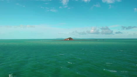 Vista-Aérea-Hacia-El-Arrecife-De-La-Isla-Slade,-Día-Soleado,-En-El-Parque-Marino-De-La-Gran-Barrera-De-Coral,-Mar-De-Coral,-Australia---Acercándose,-Disparo-De-Drones