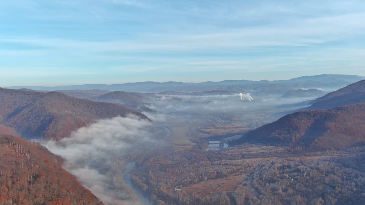 Morning fog in valley between mountain slopes the beautiful panorama