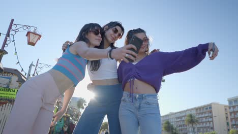 three women taking a selfie on a city street