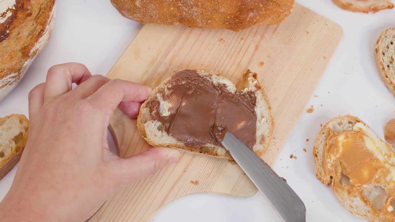 Spreading Chocolate Hazelnut Spread on a Slice of Bread