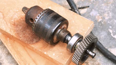 Handheld-shot-of-the-gear-and-bearing-part-of-a-power-drill-equipment-used-for-carpentry-and-construction-being-disassembled-to-fix-a-damaged-piece