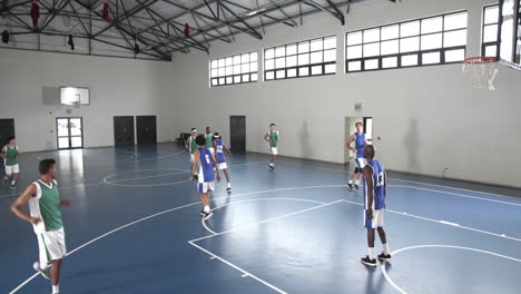 basketball players competing in gym, focused on game and teamwork