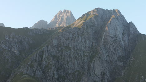 4k uhd drone inclinado hacia arriba revela picos de montaña al atardecer en el norte de italia