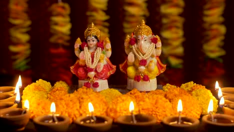 diwali celebrations with traditional marigold flowers, diya (light) and idol of the hindu god, ganesha and lakshmi