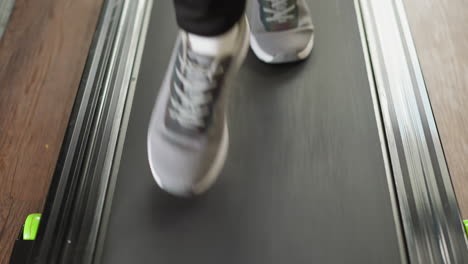 close-up of a person running on a treadmill at the gym