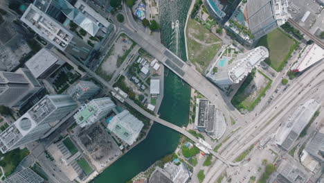 Top-down-panning-shot-of-modern-tall-buildings-along-river-or-water-canal-in-city-on-sunny-day.-Miami,-USA