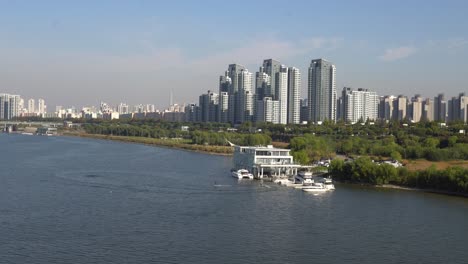 View-on-Banpo-bridge,-South-part-of-Seoul,-Han-river-Park,-and-2-people-riding-jetboards