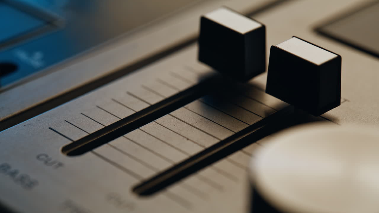 Musician hand adjusting sound balance on vintage console in dark room closeup